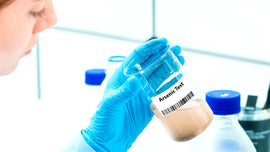 Lab technician holding an arsenic water test sample – AquaEssence arsenic in groundwater blog